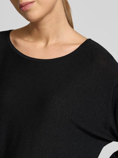 Frauenmodel trägt Relaxed Fit Pullover aus Viskose-Mix in Strick-Optik von comma, schwarzer Glitzer-Look, Nahaufnahme Oberkörper.