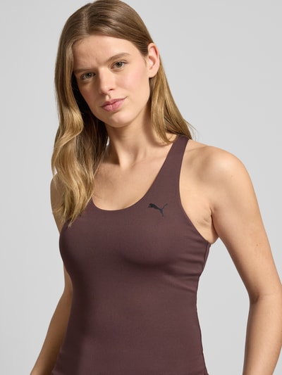 Frauenmodel trägt Slim Fit Top mit integriertem Bustier von PUMA aus Elastischer-Material-Mix, Logo-Print, Ärmelloses-Design, Rundhalsausschnitt, Rückenlänge bei Größe S: 44 cm; Nahaufnahme Oberkörper.