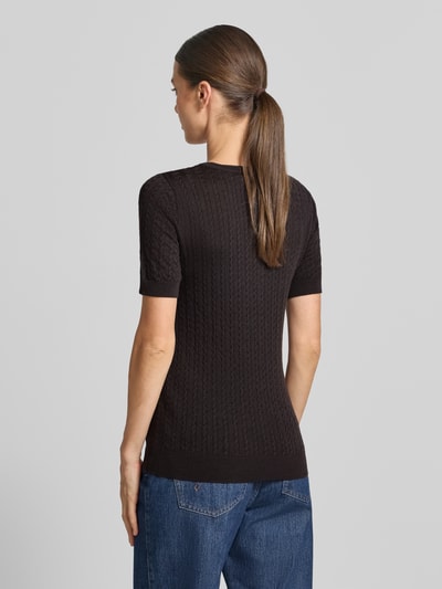 Frauenmodel trägt Wollpullover aus reiner Wolle Modell 'MEADIE' von Cph Muse, Zopfmuster, kurzärmelig, Strick-Optik, Rückansicht