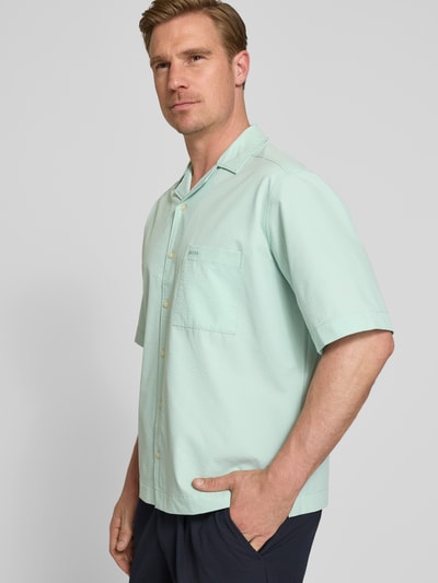 Männermodel trägt Relaxed Fit Freizeithemd mit Seersucker-Verarbeitung Modell 'LAPISY_M' von BOSS Orange in Mint, Nahaufnahme Oberkörper.