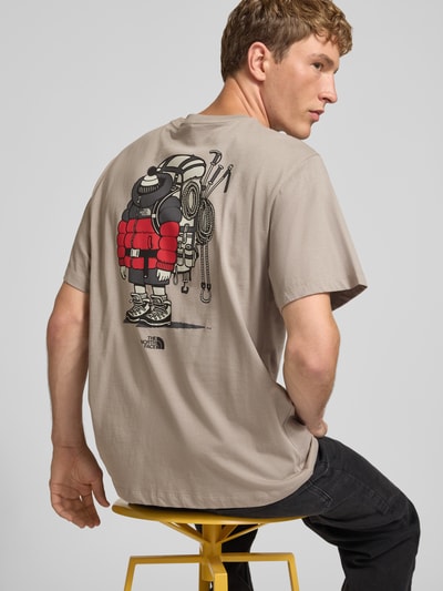 Männermodel trägt T-Shirt aus reiner Baumwolle Modell 'Gear Up Get Out' von The North Face, Regular Fit, Rückenprint, Ganzkörperansicht Rückansicht.