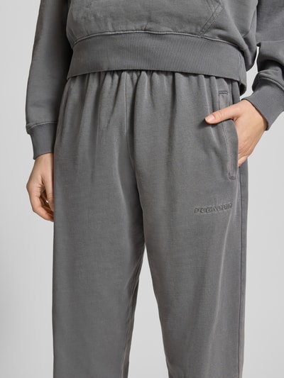 Männermodel trägt High Waist Sweatpants mit elastischem Bund von Pegador z bawełnianą mieszanką, logo, kieszenie, zbliżenie na biodra