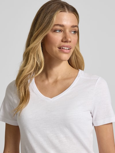 Frauenmodel trägt Regular Fit T-Shirt aus reiner Baumwolle von Tom Tailor, weiß, V-Ausschnitt, kurzarm, Flammgarn-Optik, Nahaufnahme Oberkörper.