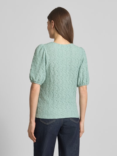 Frauenmodel trägt Blusenshirt mit Strukturmuster Modell 'FALL' von Vila aus Material-Mix mit Stretch-Anteil, Regular-Fit, Rückenlänge 53 cm, Ärmellänge 31 cm, Rundhalsausschnitt, Ganzkörperansicht Rückansicht.
