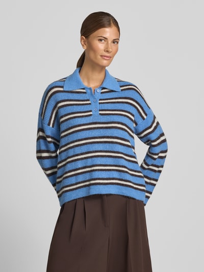 Frauenmodel trägt Pullover mit Woll-Anteil und kurzer Knopfleiste von Smith and Soul, blau-braun gestreift, Material-Mix, Polokragen, Loose Fit, überschnittene Schultern, Ganzkörperansicht von vorne.