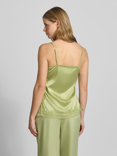 Kobieta nosi Regular Fit Top mit Spitzenbesatz von Gina Tricot z elastycznej mieszanki materiałów, satyna, cienkie ramiączka, długość tyłu w rozmiarze S: 47 cm, zielony kolor, koronka, gładka tekstura. Ganzkörperansicht Rückansicht.