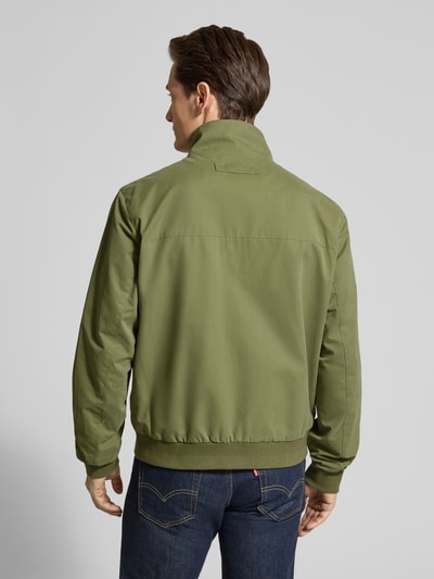 Männermodel trägt Jacke mit Stehkragen und Zweiwege-Reißverschluss von Gant in Olivgrün, Regular Fit, Material-Mix, Ganzkörperansicht Rückansicht.