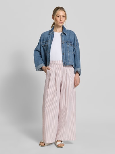Kobiece model prezentuje spodnie Wide Leg Hose mit elastischem Bund od Apricot, bawełna, wzór na całej powierzchni, szerokość w rozmiarze S 37 cm, długość wewnętrzna nogawki 73 cm, widok całej sylwetki z przodu.