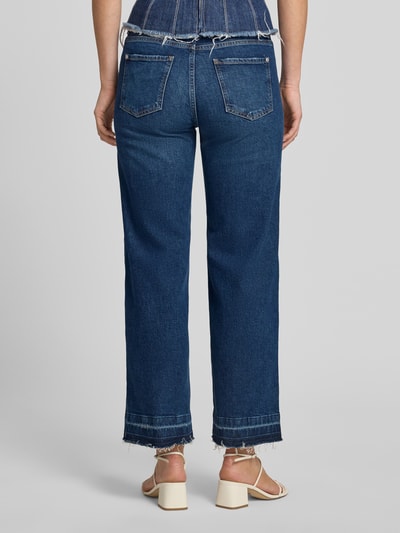 Frauenmodel trägt Jeans in verkürzter Passform mit Fransen von JOOP! aus dunkelblauem Baumwoll-Mix mit Stretch-Anteil, Eingrifftaschen, Ganzkörperansicht Rückansicht.