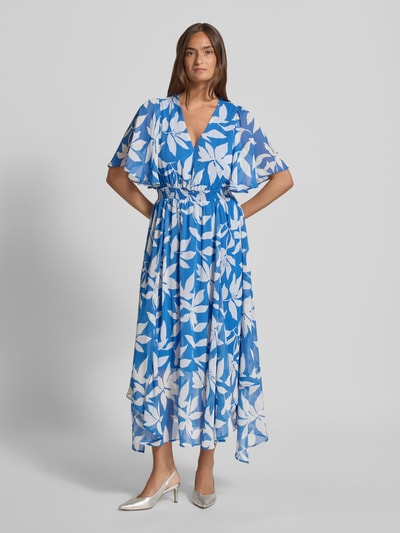 Vrouwenmodel draagt Tailliertes Chiffonkleid mit Allover-Muster van s.Oliver RED LABEL in blauw-wit met grafisch bloemenmotief, v-hals, korte vlindermouwen, getailleerde fit, gerafelde tailleband, maxi-lengte, licht doorschijnende crêpe chiffon stof, geheelopname van voren