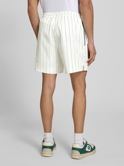Männermodel trägt Shorts mit Streifenmuster und elastischem Bund von BLKVIS in Weiß mit Regular-Fit, Label-Stitching, Ganzkörperansicht Rückansicht.