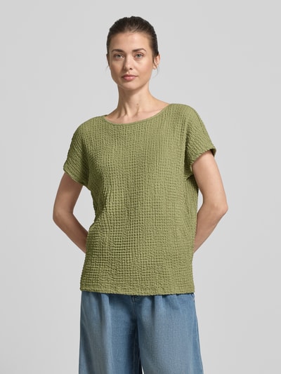 Modelka kobieca nosi Relaxed Fit T-Shirt mit Strukturmuster od s.Oliver RED LABEL, limonkowy kolor, krótki rękaw, dekolt okrągły, materiał crinkle, widok całej sylwetki z przodu.