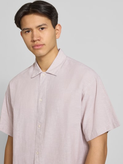 Männermodel trägt Regular Fit Freizeithemd aus Baumwoll-Leinen-Mix von Jack & Jones in hellem Rosaton, Knopfleiste, Kentkragen, Nahaufnahme Oberkörper. Modell BREEZE, Rückenlänge 73 cm, Schulterbreite 61 cm, Ärmellänge 26 cm.