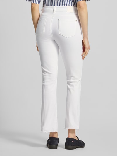 Frauenmodel trägt Bootcut Jeans mit Fransen Modell 'SHAKIRA' von Brax in Weiß mit verkürzter Passform, Ganzkörperansicht Rückansicht.