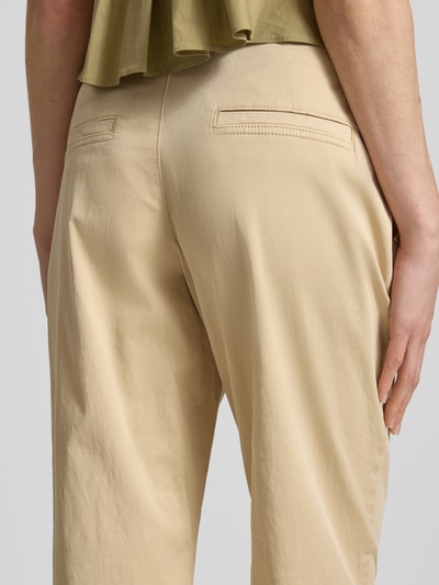 Frauenmodel trägt Regular Fit Chino aus Baumwoll-Mix von s.Oliver RED LABEL in Beige, glatte Twillstruktur, angedeutete Gesäßtaschen, Nahaufnahme Rückansicht.