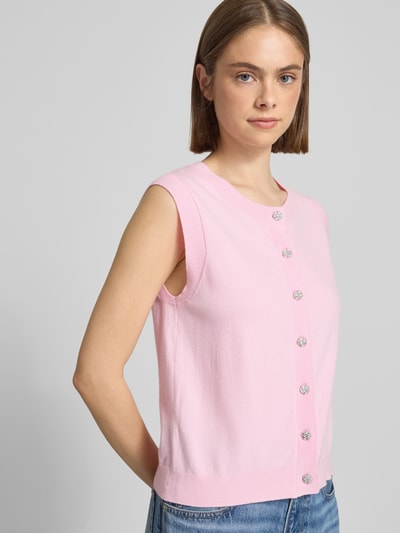 Frauenmodel trägt Regular Fit Pullunder aus Viskose-Mix Modell 'ORINA' von Pieces in Rosa mit Zierknöpfen, Feinstrick, Nahaufnahme Oberkörper.
