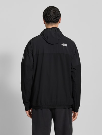 Männermodel trägt schwarzen Hoodie mit Reißverschluss und Logo von The North Face, Regular Fit, Rückenansicht, Ganzkörperansicht Rückansicht.