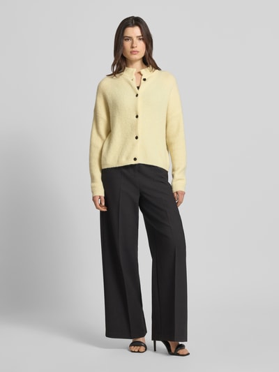 Kobiece model prezentuje Regular Fit Cardigan aus Alpaka-Mix Modell 'Alpha' von Gestuz, kolor jasnobeżowy, stójka, imitacja dzianiny, elastyczna mieszanka wełny z alpaki i mieszanka wełny escorial, krój regular fit, listwa guzikowa na całej długości, elastyczne wykończenia, długość tyłu w rozmiarze S: 55 cm, długość rękawa w rozmiarze S: 48 cm, widok całej sylwetki z przodu.