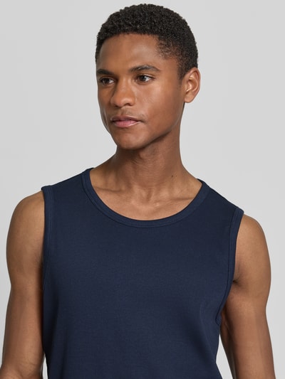 Männermodel trägt Slim Fit Tank Top aus Baumwoll-Mix von s.Oliver RED LABEL in Optik: Unifarben, Struktur: Feinripp, Nahaufnahme Oberkörper.