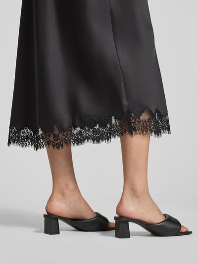 Frauenmodel trägt Ausgestellter Midi-Rock mit elastischem Bund Modell 'JESSA' von PIECES in Schwarz mit Spitzendetail, Ganzkörperansicht Rückansicht. Damen Midi-Rock.