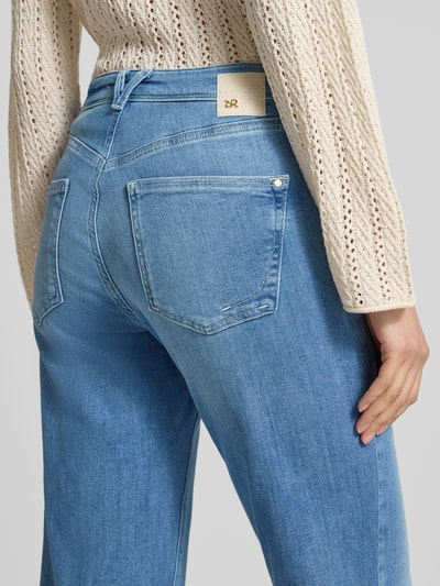 Vrouwenmodel draagt Flared fit jeans uit katoenmix model 'NELLA' van Raffaello Rossi, lichtblauw met steekzakken, detailopname rugaanzicht.