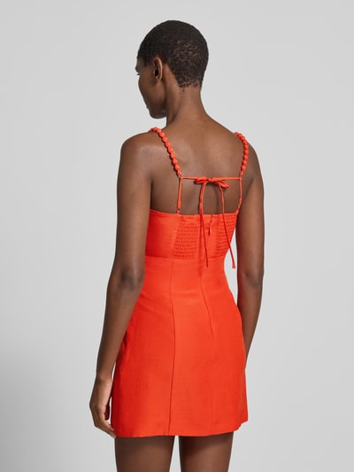 Frauenmodel trägt Cocktailkleid aus Viskose mit floraler Applikation von Forever New, leuchtendes Orange, taillierter Schnitt, Ganzkörperansicht Rückansicht.