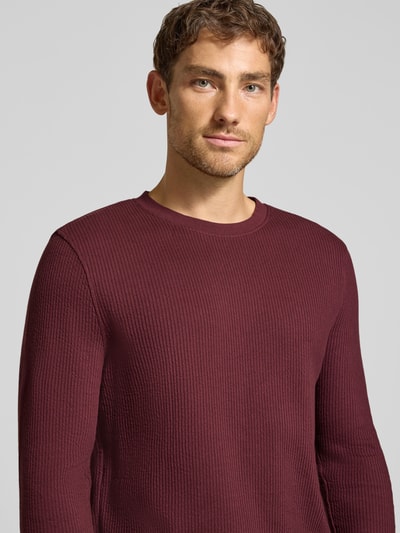 Männermodel trägt Longsleeve mit Ripp-Struktur von MCNEAL in Dunkelrot, reine Baumwolle, gerader Schnitt, Nahaufnahme Oberkörper.