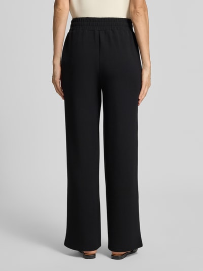 Vrouwenmodel draagt Wide Leg Sweatpants aus Viskose-Mix van Varley in zwart met Persplooien, elastische band, comfortbroekdesign, Binnenbeenlengte maat S 78 cm, viscosemix met stretch, Ganzkörperaanzicht achterkant.