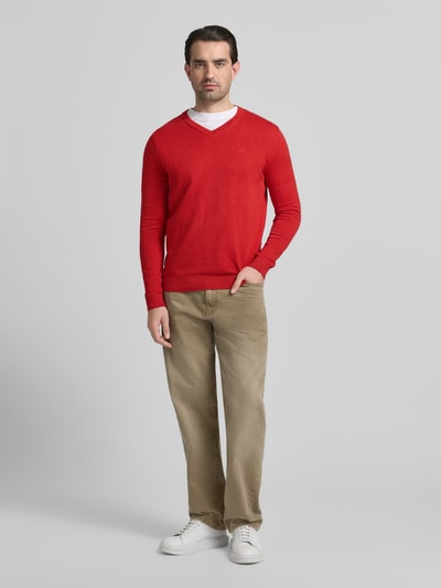 Männermodel trägt Regular Fit Pullover aus reiner Baumwolle von Tom Tailor, effen rood, fijngebreid, logo-stiksel, V-hals, lange mouw, geribbelde boorden, materiaal katoen, ganzkörperansicht von vorne