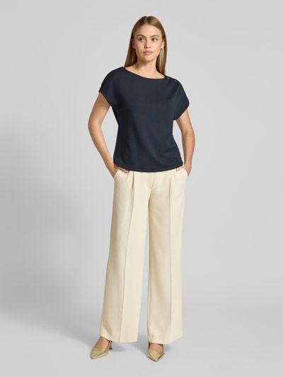 Frauenmodel trägt T-Shirt mit Zierknöpfen und Rundhalsausschnitt von Comma, Viskose-Mix mit Stretch-Anteil, Relaxed-Fit, Ganzkörperansicht von vorne.
