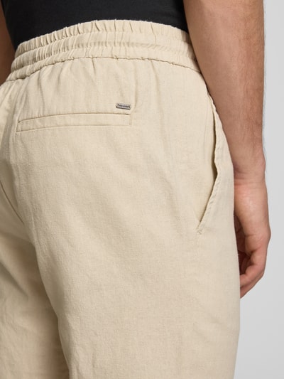 Männermodel trägt Tapered Leinenhose aus Baumwoll-Leinen-Mix Modell 'LINUS' von Only & Sons in Melange-Optik, Nahaufnahme Rückansicht