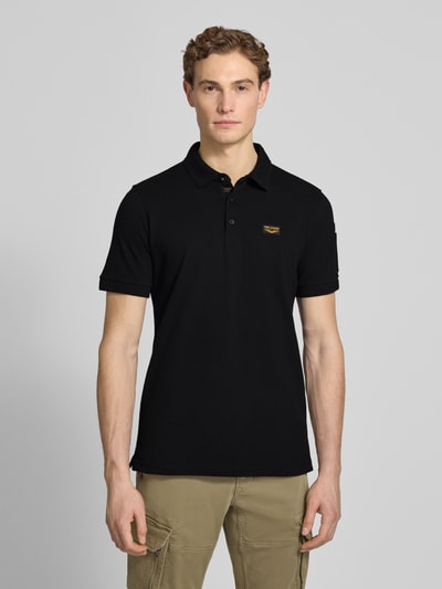 Mannenmodel draagt Slim Fit poloshirt met labelstitching model 'TRACKWAY' van PME Legend, mix van katoen en elastaan, knoopsluiting, ruglengte bij maat M 74 cm, heren poloshirt, geheel zwarte kleur, effen structuur, detailopname bovenlichaam, vooraanzicht.