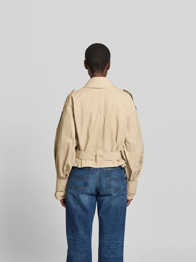Frauenmodel trägt Jacke aus reiner Viskose Modell 'ZYNIA' von IRO in Beige mit Bindegürtel und Eingrifftaschen, lockere Passform, Ganzkörperansicht Rückansicht. Rückenlänge bei Größe 36: 52 cm, Brustweite 52 cm, Ärmellänge 61 cm.