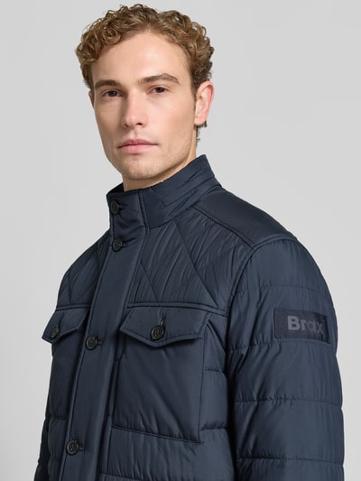 Männermodel trägt dunkelblaue Regular Fit Steppjacke mit Label-Patch von Brax, sichtbare Steppnähte, Nahaufnahme Oberkörper, Herren Steppjacke von Brax