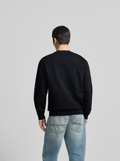 Männermodel trägt Cool Fit Sweatshirt aus reiner Baumwolle von Dsquared2 in Schwarz, elastische Abschlüsse, Ganzkörperansicht Rückansicht.
