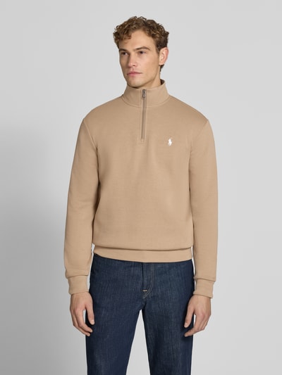 Męski model nosi Regular Fit Troyer aus Baumwoll-Mix von Polo Ralph Lauren, beżowy, granatowe spodnie, gładka faktura, Ganzkörperansicht von vorne.