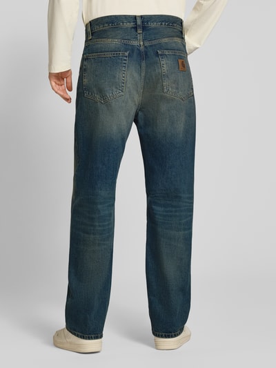 Männermodel trägt Straight Fit Jeans aus reiner Baumwolle Modell 'Aaron' von Carhartt Work In Progress, 5-Pocket-Design, Ganzkörperansicht Rückansicht.