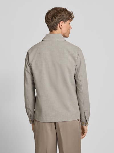 Männermodel trägt Regular Fit Hemdjacke mit Brusttaschen von Les Deux in Hellbeige, strukturierte Oberfläche, Ganzkörperansicht Rückansicht, Kentkragen, Knopfleiste, Label-Patch, Rückenlänge bei Größe M 69 cm, Schulterbreite 47 cm, Brustweite 54 cm, Ärmellänge 65 cm.
