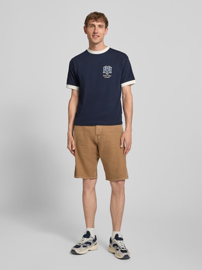 Männermodel trägt Slim Fit T-Shirt mit Motiv-Stickerei von PROHIBITED, Kontrast-Rundhalsausschnitt, Herren T-Shirt, Ganzkörperansicht von vorne.