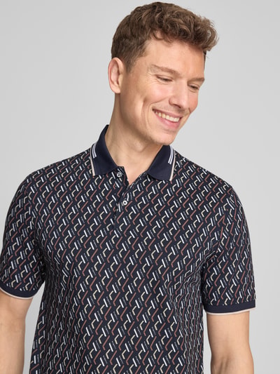 Männermodel trägt Slim Fit Poloshirt im Allover-Look von bugatti, Baumwoll-Mix mit Stretch-Anteil, Knopfleiste, Nahaufnahme Oberkörper.