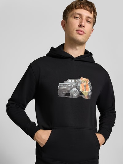 Mannelijk model draagt Relaxed Fit Hoodie uit katoenmix met motiefprint van CHILL PILL, Kangoeroezak, elastische boorden, zwart, frontale half-totaalopname.