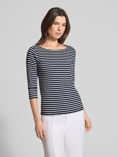 Modelka nosi Regular Fit 3/4-Shirt aus Baumwoll-Mix von Tom Tailor z paskami, bawełniany miks, napis, dekolt łódka, krój regular fit, widok z przodu całej sylwetki.