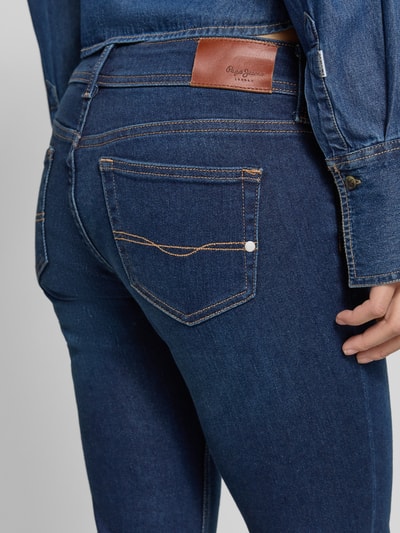 Frauenmodel trägt Slim Fit Bootcut Jeans aus Baumwoll-Mix Modell 'PIMLICO' von Pepe Jeans in Denim-Optik mit Label-Patch, Detailaufnahme