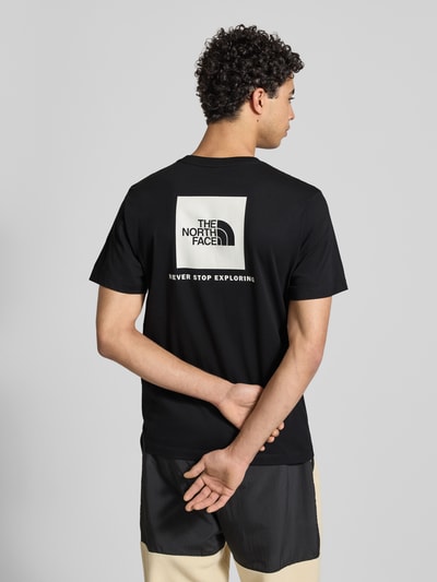 Männermodel trägt zwart Regular fit T-shirt van katoenmix Model 'EVOLUTION' van The North Face met labeldetail, ruglengte maat M 70 cm, Ganzkörperansicht Rückansicht.