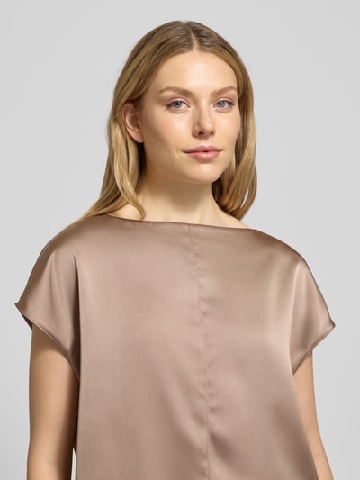 Frauenmodel trägt Blusenshirt mit Rundhalsausschnitt von OPUS in glänzendem Beige, lockerer Schnitt, glatte Textur, Nahaufnahme Oberkörper.