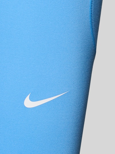 Frauenmodel trägt Leggings mit Logo und elastischem Bund von NIKE TRAINING in Blau, Material-Mix mit Stretch-Anteil, Detailaufnahme.