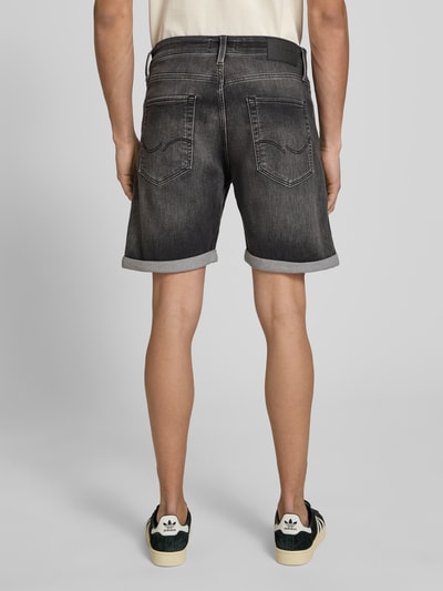 Männermodel trägt Regular Fit Jeansshorts mit Umschlag Modell 'RICK' von Jack & Jones im Used-Look, Baumwoll-Mix, Ganzkörperansicht Rückansicht. Bundweite 42 cm, Innenbeinlänge 19 cm bei Größe M.
