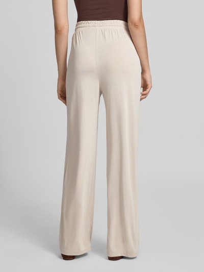 Frauenmodel trägt Weite Hose aus Viskose-Mix Modell 'ANORA' von PIECES, beige, lockerer Schnitt, glatte Textur, Ganzkörperansicht Rückansicht. Damen Weite Hose von PIECES