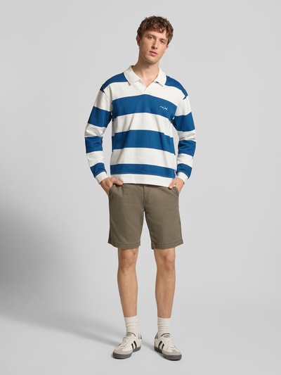 Männermodel trägt Chino Shorts aus Baumwoll-Mix mit Leinen-Anteil von Levi's®, olivgrün, gerader Schnitt, Ganzkörperansicht von vorne