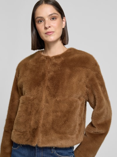 Frauenmodel trägt Regular Fit Jacke aus Kunstfell von Rich & Royal in brauner Farbe mit aufgesetzten Taschen, Nahaufnahme Oberkörper. Rückenlänge 52 cm, Schulterbreite 46 cm, Brustweite 49 cm, Ärmellänge 64 cm.